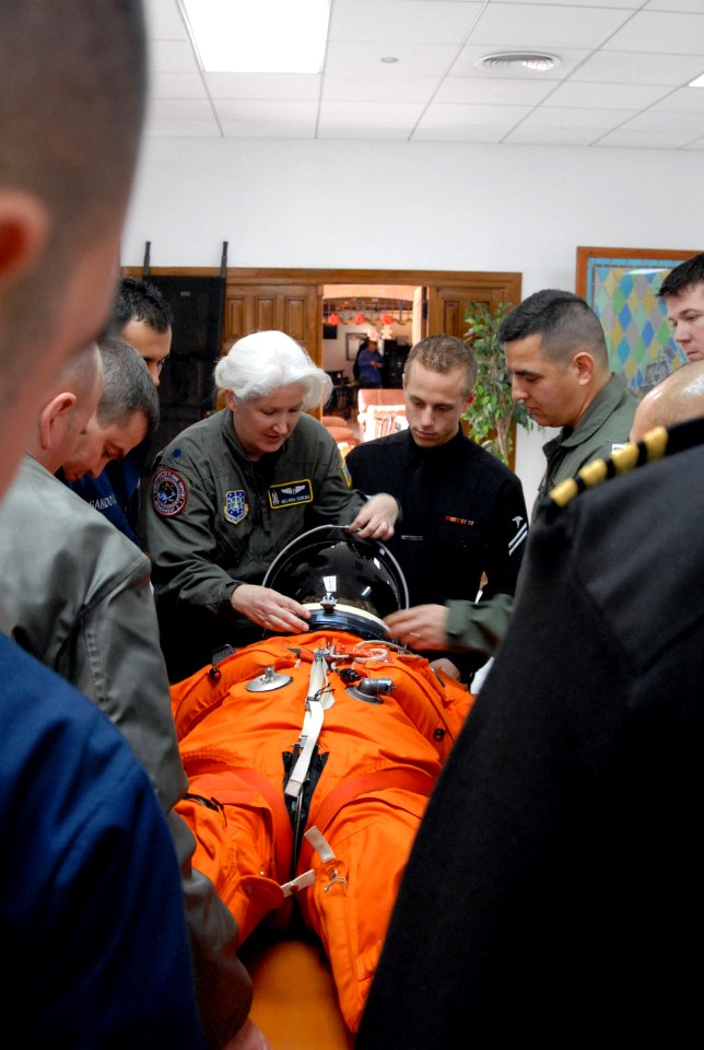 US Navy 081209-N-1825E-015 NASA training team member Lt. Col. Melinda Screws shows students how to adjust a space suit helmet on Naval Station Rota Nurse LT. Lisa Steiner
