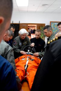 US Navy 081209-N-1825E-015 NASA training team member Lt. Col. Melinda Screws shows students how to adjust a space suit helmet on Naval Station Rota Nurse LT. Lisa Steiner