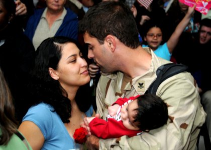 US Navy 081215-N-9095H-046 Gunner's Mate 2nd Class William Kapun is greeted by his family at the Naval Station Norfolk Air Mobility Command terminal