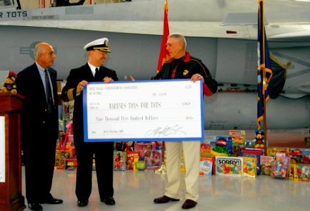 US Navy 081216-N-5617R-047 Capt. Michael Kelly, commanding officer of Fleet Readiness Center Southwest, presents toys and a check to retired Gunnery Sgt. R. Lee Ermey to benefit the Marine Corps Reserve Toys for Tots program