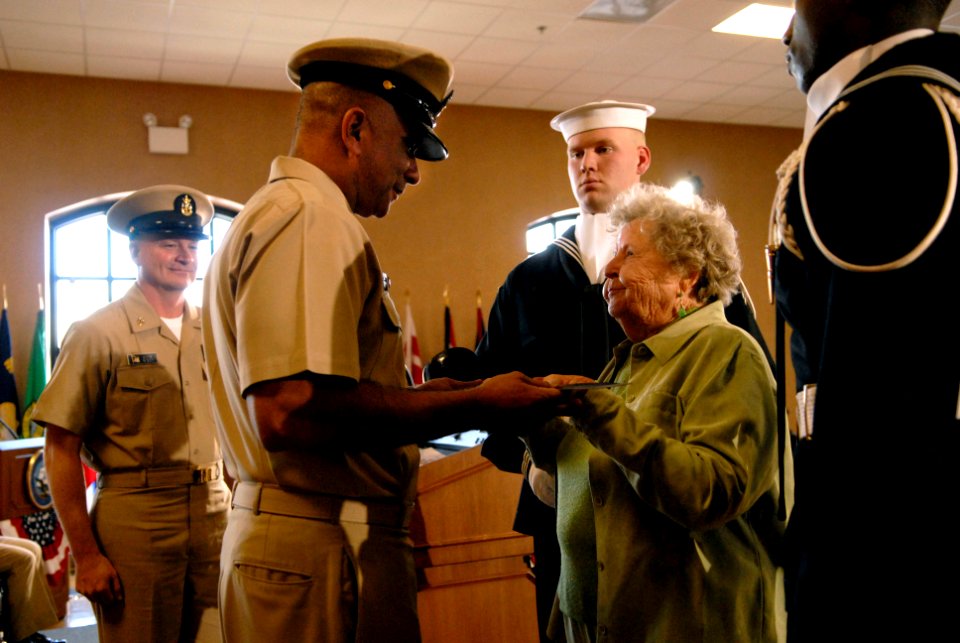 US Navy 081212-N-9818V-329 Ima Black, widow of the first Master Chief Petty Officer of the Navy, hands the cutlass to Master Chief Petty Officer of the Navy Joe R. Campa, Jr. during the Passing of the Cutlass ceremony