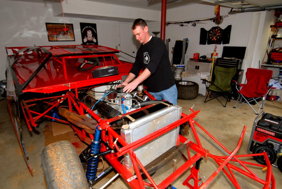 US Navy 081220-N-6724S-011 Aviation Ordnanceman 1st Class David Steele, assigned to Pre-Commissioning Unit George H.W. Bush (CVN 77), works on his Victory Lap Late Model Series race car in his garage