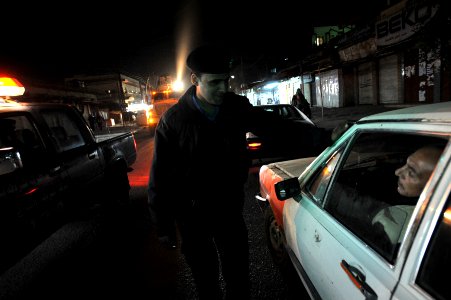 US Navy 081217-N-1810F-672 An Iraqi policeman stops a vehicle during a walking patrol in the Rashid district of Baghdad photo