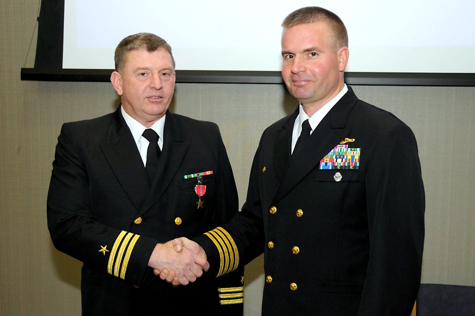 US Navy 081218-N-1598C-003 Capt. Eric Jabs presents Cmdr. Steven Masdon the Bronze Star