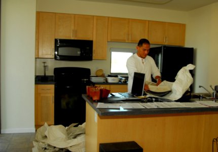 US Navy 081219-N-5617R-048 hief Storekeeper Abraham Racela unpacks dishes after moving into the Pacific Beacon bachelor housing at Naval Base San Diego