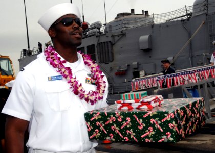 US Navy 081219-N-9758L-138 Information Systems Technician 2nd Class Ryan Jurode departs USS Reuben James (FFG 57) with Christmas presents during the ship's return to Naval Station Pearl Harbor