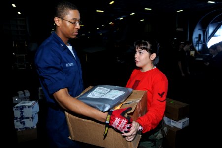 US Navy 090104-N-2908M-004 Postal Clerk 3rd Class Justin Richard gives mail to Aviation Ordnanceman 3rd Class Ivianna Ortiz during mail call