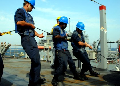 US Navy 090101-N-3392P-089 Line handlers heave line to maintain tension during a replenishment at sea