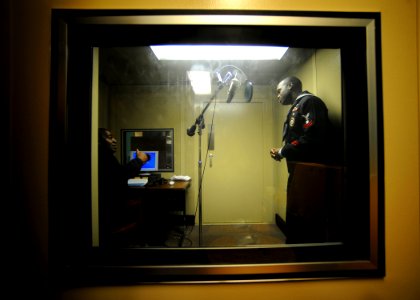 US Navy 090105-N-7948R-005 Electrician's Mate Second Class Curtis Bembow talks with Mass Communication Specialist 1st Class Vaughn McMillian during a radio interview for Navy Radio News