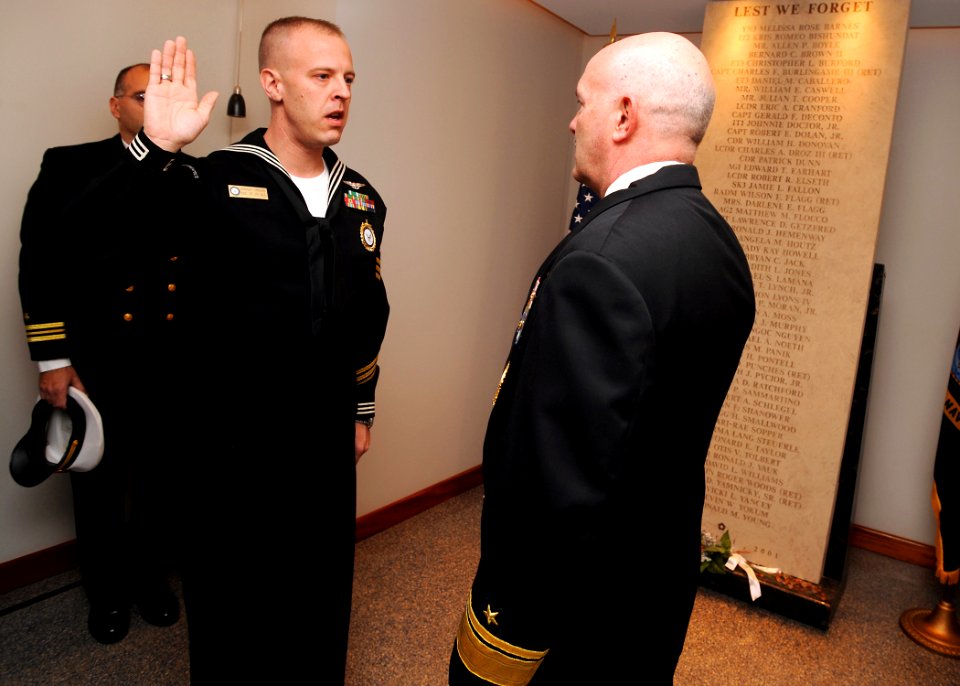 US Navy 090106-N-7948R-005 Rear Adm. Joseph F. Kilkenny reenlists Navy Career Counselor 1st Class Josh Vinson