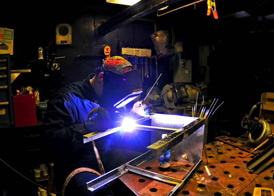 US Navy 090113-N-4774B-042 Hull Maintenance Technician Brian Winter welds cross braces to an aluminum chair