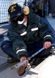 US Navy 090113-N-2013O-002 Boatswain's Mate Seaman Jimmy Self sands a hatch