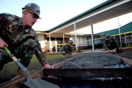 US Navy 090108-N-3674H-036 Builder 2nd Class Matthew Speece adjusts an expansion joint during a concrete pour photo