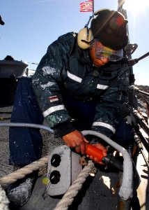 US Navy 090113-N-2013O-003 Boatswain's Mate Seaman Richard Jett sands a fiddleboard