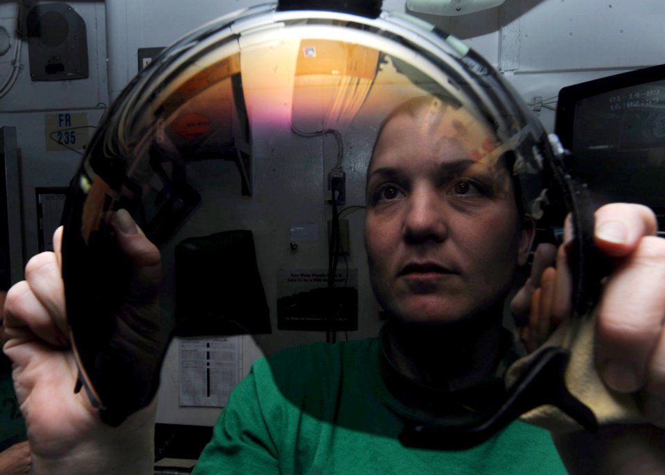 US Navy 090114-N-2908M-003 Aircrew Survival Equipmentman 1st Class Denise Foote cleans and inspects pilot's face shields aboard the aircraft carrier USS Theodore Roosevelt (CVN 71)