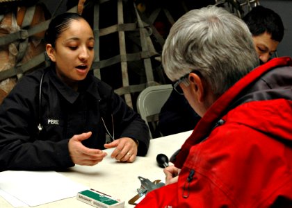US Navy 090119-N-9134V-026 Operations Specialist Seaman Elisa Perez performs a health assessment on an evacuee during a non-combatant evacuation operation exercise
