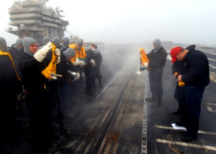 US Navy 090115-N-9079D-024 Sailors practice donning an abandon-ship life preserver during an abandon ship drill aboard the aircraft carrier USS Abraham Lincoln (CVN 72) photo