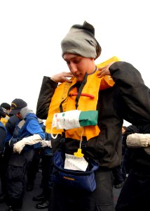 US Navy 090115-N-9079D-039 Aviation Boatswain's Mate Equipment Airman Matthew A. Whitt practices donning an abandon-ship life preserver during an abandon ship drill aboard the aircraft carrier USS Abraham Lincoln (CVN 72)