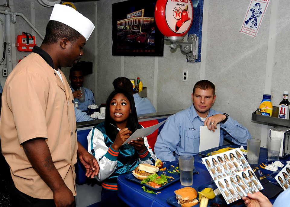 US Navy 090121-N-1082Z-032 A Miami Dolphins Cheerleader signs an autograph for Culinary Specialist 2nd Class Damon D. Mathis, from Ft. Lauderdale Fla., aboard the guided-missile cruiser USS Vella Gulf (CG 72)