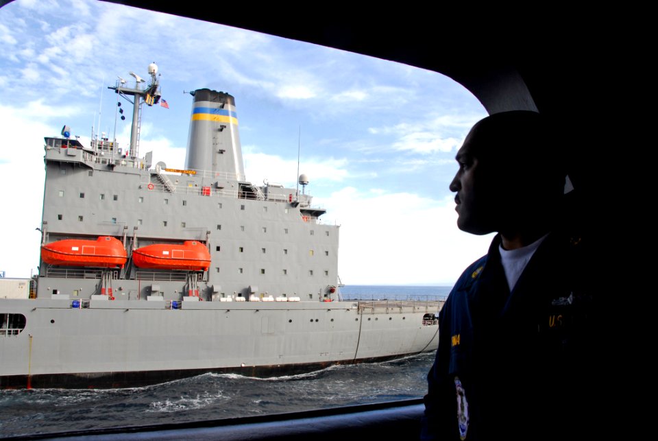 US Navy 090121-N-6597H-029 Chief Hull Technician Frank Pina observes an underway replenishment between USNS Henry J. Kaiser (T-AO 187) and USS John C. Stennis (CVN 74)