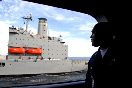 US Navy 090121-N-6597H-029 Chief Hull Technician Frank Pina observes an underway replenishment between USNS Henry J. Kaiser (T-AO 187) and USS John C. Stennis (CVN 74)