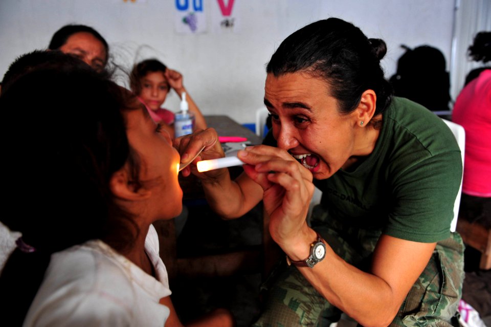 US Navy 110706-F-NJ219-060 Brazilian navy Lt. Cmdr. Daniella Moura, a physician from Rio de Janeiro, Brazil, examines a patient during a Continuing