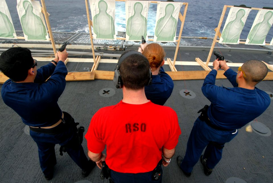 US Navy 090121-N-1688B-053 Gunner's Mate 1st Class Benjamin West gives orders to Sailors during a 9mm weapons qualification