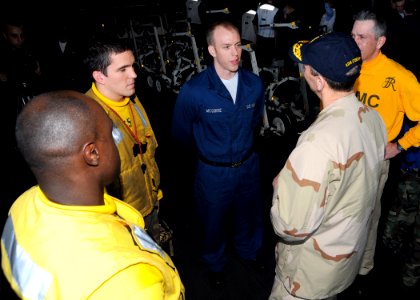 US Navy 090119-N-7571S-004 Adm. Jonathan W. Greenert, speaks with Seaman Christopher McGuire and Aviation Boatswain's Mate (Handling) Victor Seeley and in the hangar bay during his brief visit aboard the aircraft carrier USS Th