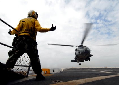 US Navy 090123-N-6278K-293 Aviation Boatswain's Mate (Handling) 1st Class Jaime Valencia directs the landing of an HH-60H Sea Hawk helicopter