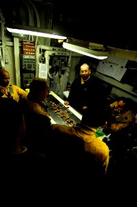US Navy 090120-N-6538W-009 Aviation Boatswain's Mate 1st Class Gene Dunn, from Marysville, Wash., center, briefs Sailors about upcoming aircraft movements in hangar deck control