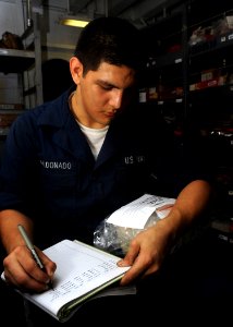 US Navy 090120-N-2908M-001 Storekeeper Seaman Serafin Maldonado records and stores parts aboard the aircraft carrier USS Theodore Roosevelt (CVN 71)