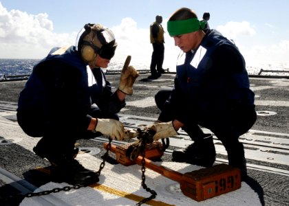 US Navy 090115-N-9758L-576 Sailors assigned to the guided-missile cruiser USS Chosin (CG 65) adjust a chock and chain for an incoming helicopter during the Commander, Naval Surface Group Middle Pacific Surface Combatant Group S