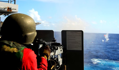 US Navy 090123-N-6597H-237 Aviation Ordnanceman 3rd Class Joshua Hagerty, from Philadelphia, Mo., fires a .50-caliber machine gun at a photo