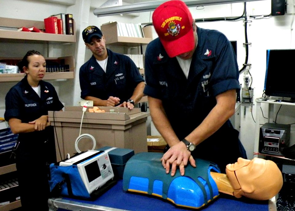 US Navy 090124-N-2604W-572 Hospital Corpsman 3rd Class Sarah Pilipovich and Hospital Corpsman 2nd Class Robert Sides look on as Machinery Repairman 2nd Class Joseph Trotta practices cardiopulmonary resuscitation