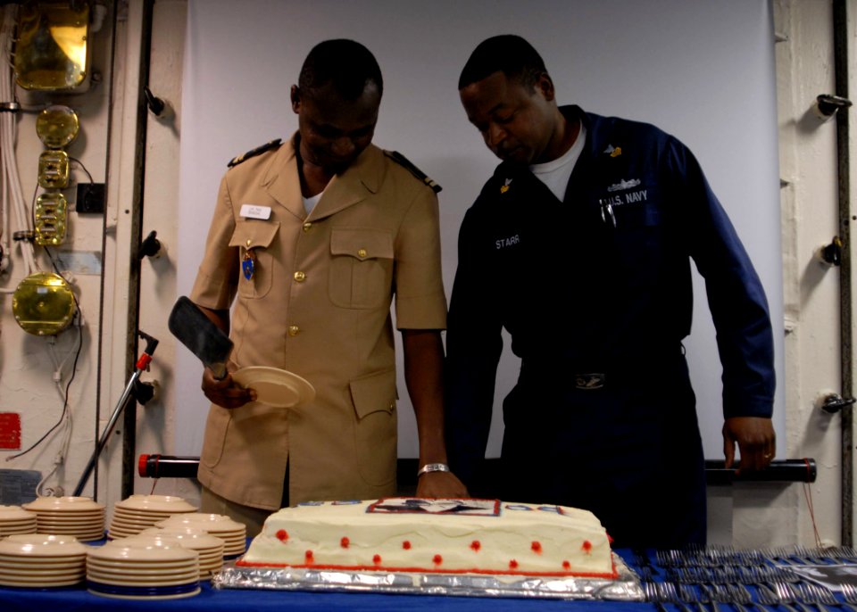 US Navy 090119-N-1688B-462 Lt. Jean Pierre Tine, Senegal Navy and Aviation Boatswain's Mate (Handling) 1st Class Leonard Starr cut a cake during a Martin Luther King Jr. remembrance ceremony aboard the amphibious transport dock