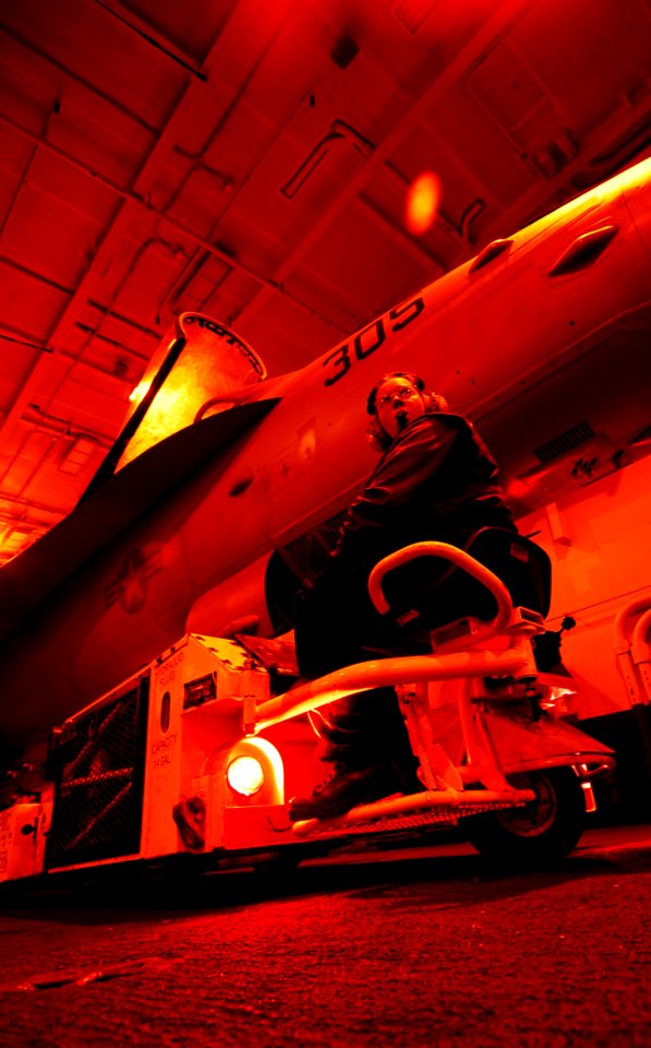 US Navy 090122-N-6538W-051 Aviation Boatswain's Mate (Handling) Airman Natasha Greely, from Stafford, Va., uses a spotting dolly to maneuver an F-A-18C Hornet assigned to the