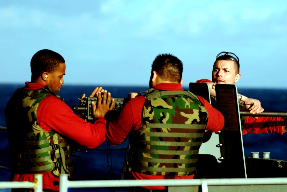 US Navy 090124-N-8157C-032 Sailors hange out a .50-caliber machine gun during a live-fire exercise aboard the aircraft carrier USS John C. Stennis (CVN 74)