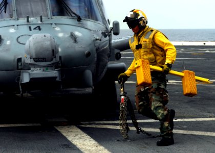 US Navy 090123-N-6278K-393 Aviation Support Equipment Technician 2nd Class Anthony Juarez chocks and chains an HH-60H Sea Hawk helicopter
