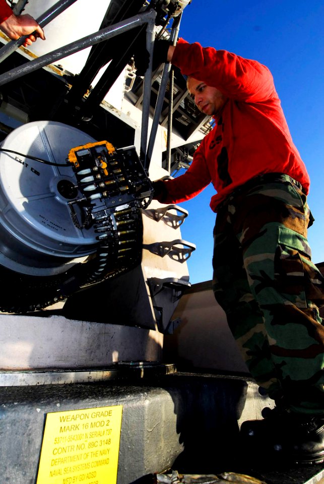 US Navy 090123-N-6538W-137 Fire Controlman 2nd Class Kelby Castillo, from Bronx, N.Y., guides ammunition into a 20mm Phalanx Close-in Weapons System during an ammunition upload aboard the aircraft carrier USS John C. Stennis (C