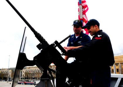 US Navy 090127-N-9552I-004 Gunner's Mate 1st Class Michael Brown assists Operations Specialist 2nd Class David Padilla with his shipboard weapons qualification