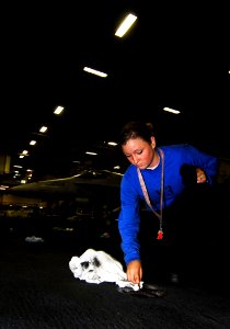 US Navy 090123-N-6538W-001 Aviation Boatswain's Mate (Handling) Airman Recruit Courteney Smith, from Oxford, Ohio, dries pad eyes in the hangar bay of aircraft carrier USS John C. Stennis (CVN 74)