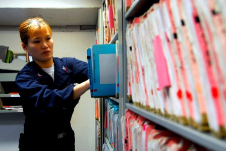 US Navy 090123-N-9760Z-004 Hospital Corpsman 2nd Class Jennifer Ross files medical records aboard the aircraft carrier USS Nimitz (CVN 68) photo