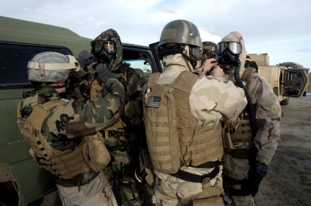 US Navy 090127-N-5821P-022 Sailors assigned to Explosive Ordnance Disposal Unit (EODMU) 8 help each other don M-45 gas masks and joint service lightweight integrated suit technology suits during a chemical warfare training exer