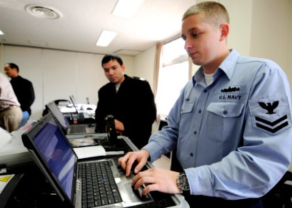 US Navy 090128-N-2638R-001 Operations Specialist 2nd Class Sean Gagne learns how to properly operate Fleet Activities Yokosuka's noncombatant evacuation operation tracking system photo
