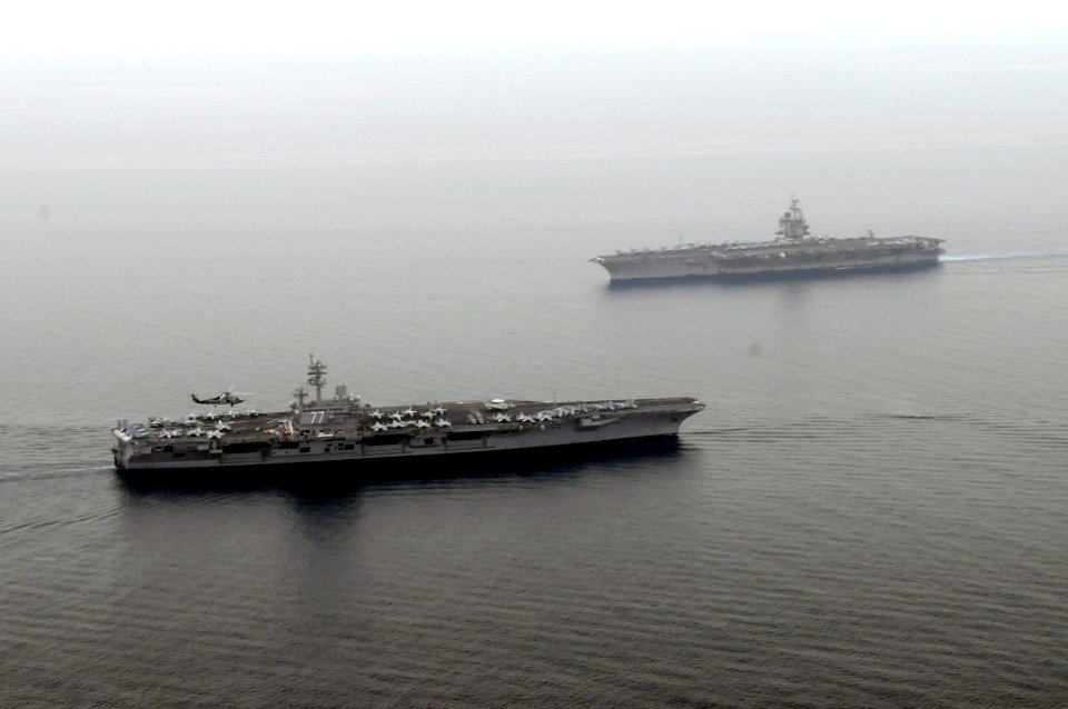 US Navy 110621-N-YZ751-121 USS George H.W. Bush (CVN 77), left, transits near USS Enterprise (CVN 65)
