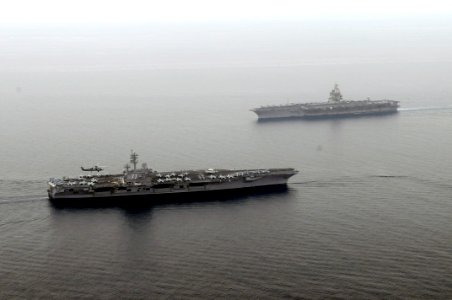 US Navy 110621-N-YZ751-121 USS George H.W. Bush (CVN 77), left, transits near USS Enterprise (CVN 65)