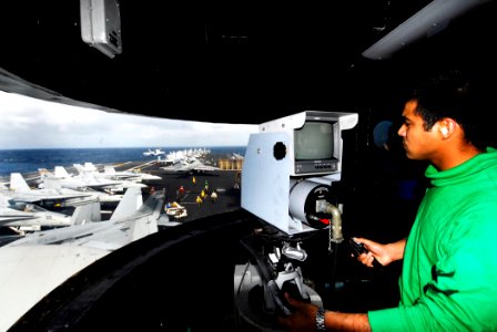 US Navy 090124-N-9610C-133 nterior Communications Electrician 3rd Class Ernesto Diaz, from Jacksonville, Fla., operates the visual landing air (VLA) camera during flight operations aboard the aircraft carrier USS John C. Stenni