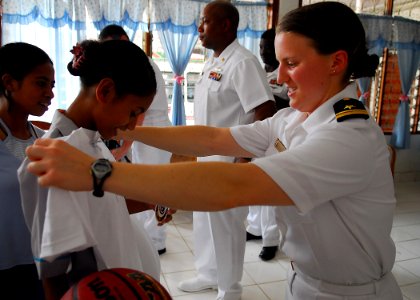 US Navy 090126-N-2013O-052 Lt. j.g. Kristina Rohlin, from Russell, Pa., assigned to the Arleigh Burke-class guided-missile destroyer USS Lassen (DDG 82), checks the size of a shirt before giving it to a girl at the Missionary D photo