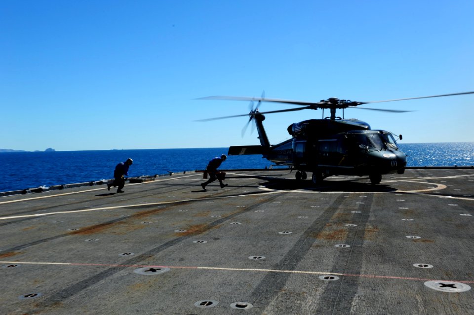 US Navy 110721-N-WA347-030 Sailors run to chock and chain an MH-60S Sea Hawk helicopter aboard USS Germantown (LSD 42)