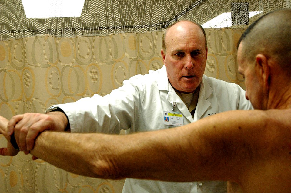 US Navy 090126-N-6326B-224 Orthopedic surgeon Capt. Dana Covey, chairman of Orthopedic Surgery at Naval Medical Center San Diego, performs a postoperative range of motion test at the orthopedic sports clinic